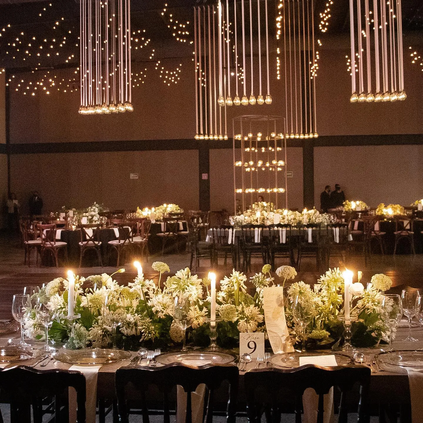 Mesa imperial iluminada con velas y camino de flores blancas