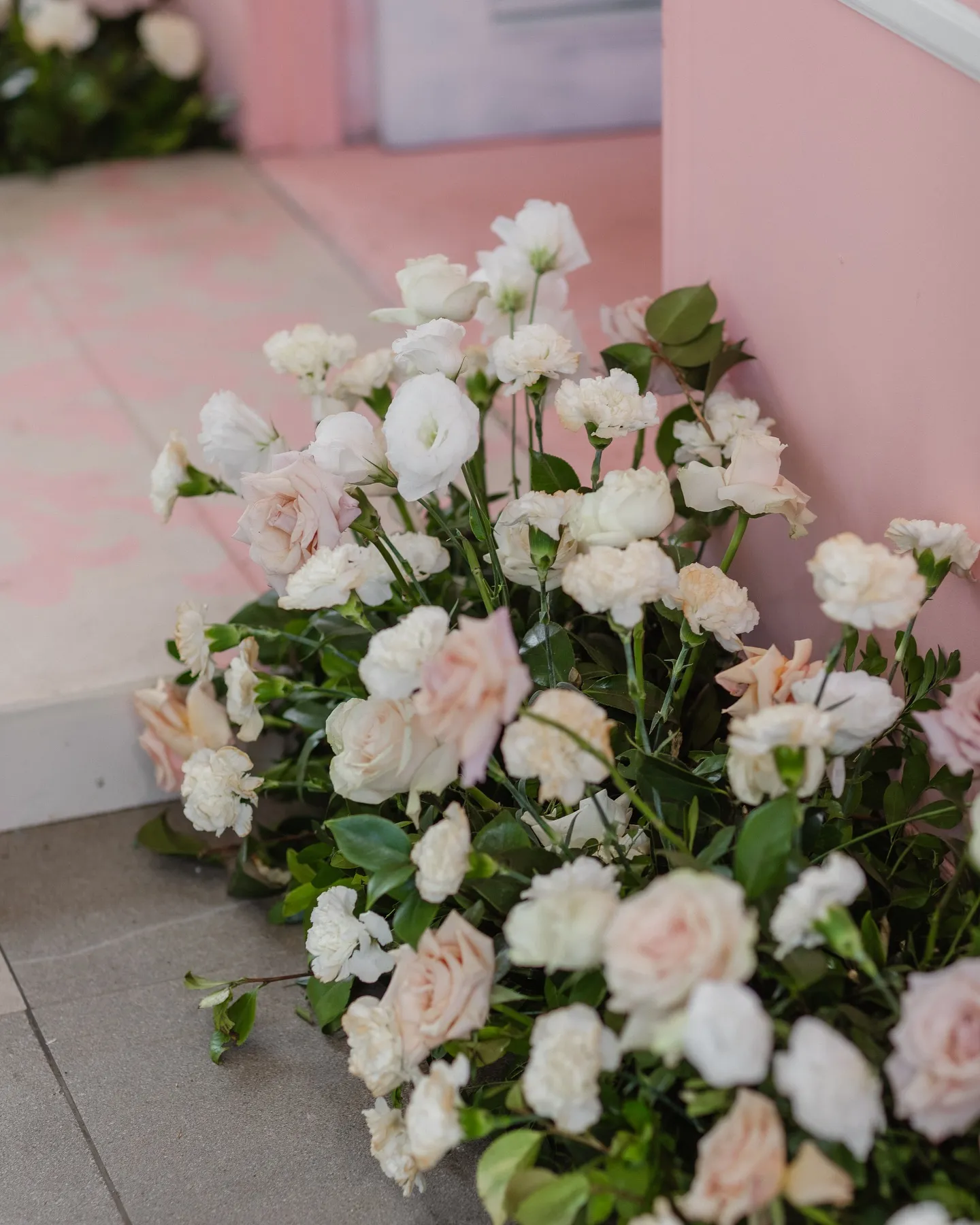 Detalle de rosas blancas y durazno en un arreglo bajo